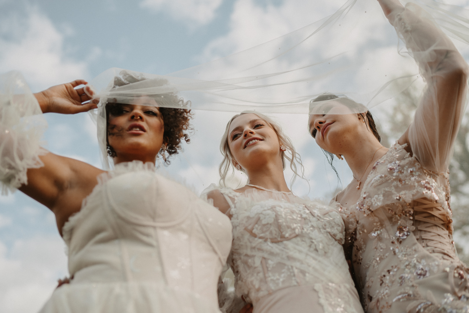 Three brides under a flowing veil at Schloss Pertenstein – an ethereal and timeless wedding moment.