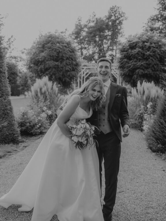 oyful wedding moment in the gardens of Birkenheide – a sweet couple laughing together at sunset, radiating love and happiness