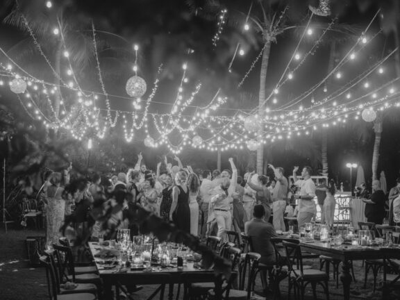 Magical outdoor wedding party at Secrets Akumal, Mexico – celebrating under a canopy of fairy lights.