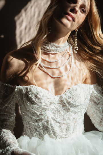 Elegant bridal portrait at Villa Pizzo – sunlight casts dreamy shadows on a pearl-adorned luxury wedding gown, creating a bespoke and sensual editorial momen