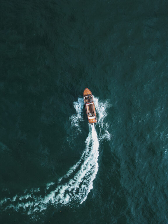 Romantic drone shot of a wedding couple on a boat ride across Lake Como – timeless elegance in a breathtaking destination