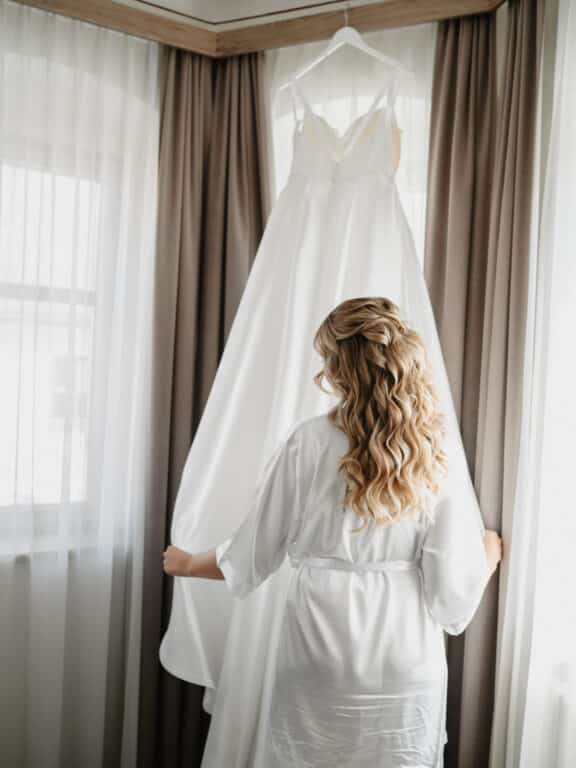 Bride getting ready, looking at her dress — Birkenheide wedding